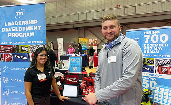 Industry representatives standing in front of their booth at the last career fair.